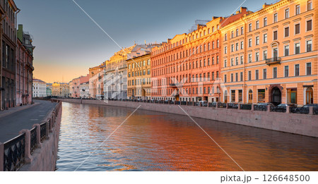 Russia, St. Petersburg, the picturesque Moika river embankment at sunset, the colored facades of houses and their reflection on the water, the beginning of river navigation without tourist boats Russia, St. Petersburg, the picturesque Moika river embankment at sunset, the colored facades of houses and their reflection on the water, the beginning of river navigation without tourist boats 126648500