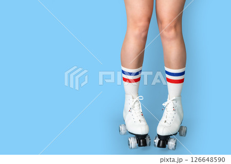 Retro roller skates on caucasian female legs with colorful socks Retro roller skates on caucasian female legs with colorful socks 126648590