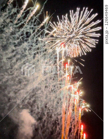 夜空と水面が織りなす幻想的な輝き。花火の美しさが時間を忘れさせ、心を奪われる瞬間です。   126649469