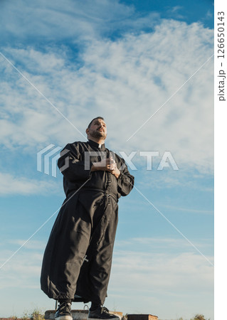 Priest Doing A Prayer In The Natural Scenery  126650143