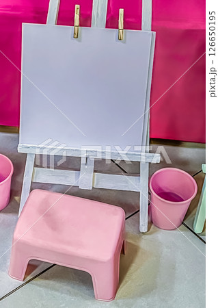 Mockup of Childrens Art Easel with Blank Paper, Pink Stool and Buckets in Playroom Setup Mockup of Childrens Art Easel with Blank Paper, Pink Stool and Buckets in Playroom Setup 126650195