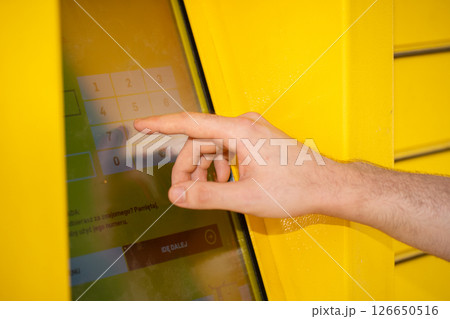 User Engaging with a Touchscreen Kiosk Located in a Bright Yellow Environment Surrounding User Engaging with a Touchscreen Kiosk Located in a Bright Yellow Environment Surrounding 126650516