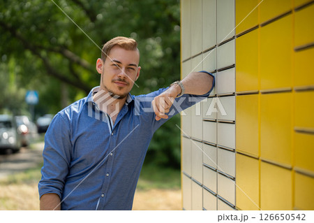 A Stylish Young Man Confidently Posing Outdoors Against a Vibrant Yellow Wall Background A Stylish Young Man Confidently Posing Outdoors Against a Vibrant Yellow Wall Background 126650542