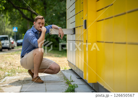 A Casual Young Man Posing Effortlessly Near a Bright Yellow Wall in an Urban Setting 126650567