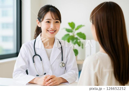 若手女医が患者と向き合う笑顔の診察風景 若手女医が患者と向き合う笑顔の診察風景 126652252
