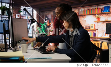 Programmer coming to AI startup office CTO manager desk to request help. Employee asks questions to senior team leader in artificial intelligence software development agency, camera B 126653332