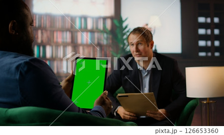 Multiethnic secret agents discussing next to isolated mockup on display, meeting in the CIA bureau to discuss important mission details. Secure information and professional camaraderie. Camera A. 126653360