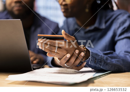 African american young couple entering credentials to renew a subscription, managing streaming services on their laptop. Couple transferring money on the browser, updating the digits. 126653532