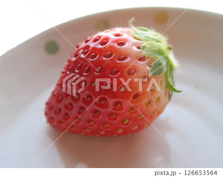 お皿に乗った一粒のヘタ付きイチゴ 126653564