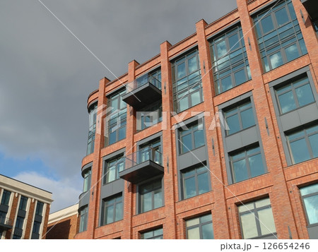 A Modern Urban Residential Building featuring Glass Balconies that enhances living experience A Modern Urban Residential Building featuring Glass Balconies that enhances living experience 126654246