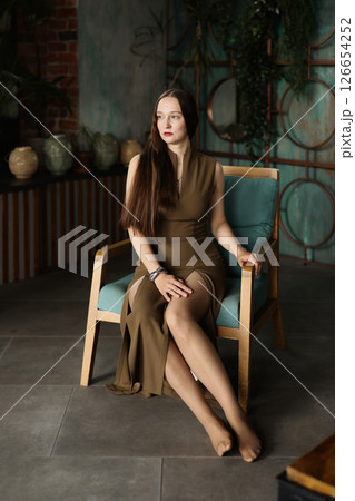 An Elegant and Stylish Woman in a Chic Dress Posing Gracefully in a Modern Interior Space 126654252