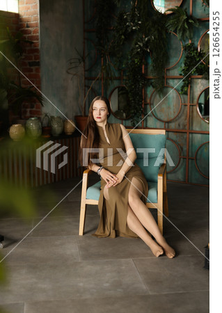 An Elegant Woman Posed Gracefully in a Modern Interior Surrounded by Beautiful Greenery An Elegant Woman Posed Gracefully in a Modern Interior Surrounded by Beautiful Greenery 126654255