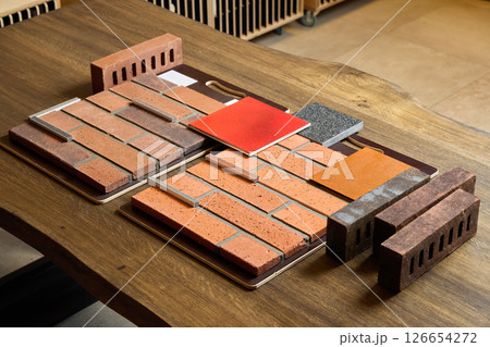 A Diverse Collection of Brick Samples Displayed on a Wooden Surface for Various Design Projects 126654272