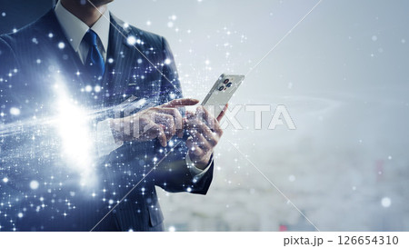 スマホを使うビジネスパーソンとテクノロジーのコンセプト　バナー・広告向け横長ビジュアル 126654310