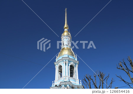 A Stunning Golden Spire of a Magnificent Church Rising Against a Beautiful Clear Blue Sky 126654416