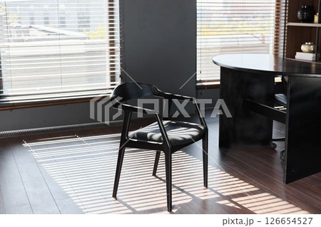 A Stylish Modern Black Chair in a Trendy Office Setting Enhancing the Overall Aesthetic Atmosphere A Stylish Modern Black Chair in a Trendy Office Setting Enhancing the Overall Aesthetic Atmosphere 126654527