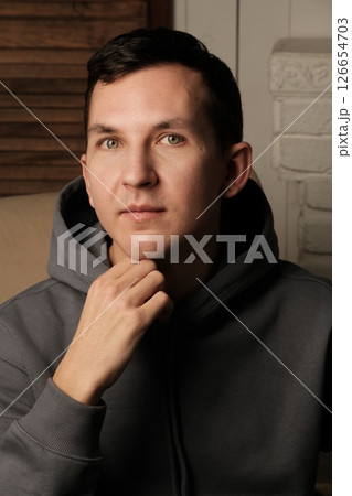 A young man in a stylish hoodie exudes a relaxed, bold demeanor, showcasing his personality A young man in a stylish hoodie exudes a relaxed, bold demeanor, showcasing his personality 126654703