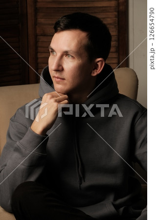 A Thoughtful Young Man Dressed in Comfortable Casual Attire, Evoking a Relaxed Atmosphere A Thoughtful Young Man Dressed in Comfortable Casual Attire, Evoking a Relaxed Atmosphere 126654790