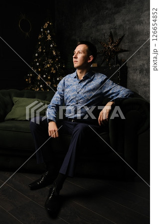 A Thoughtful and Contemplative Man Wearing a Stylish Outfit is Sitting Comfortably on a Sofa A Thoughtful and Contemplative Man Wearing a Stylish Outfit is Sitting Comfortably on a Sofa 126654852
