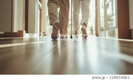 介護士と一緒に歩く高齢者の足元、温かい日差しの中の歩行訓練（介護・福祉） 126654861