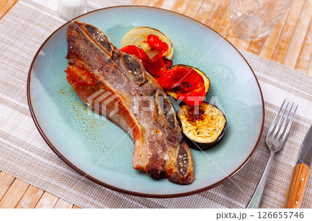 on blue plate-grilled beef ribs with fried vegetables-aubergine, pepper,onion.Spanish dish-churrasco 126655746