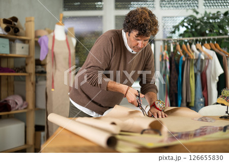 Male fashion designer cuts paper in the workshop 126655830