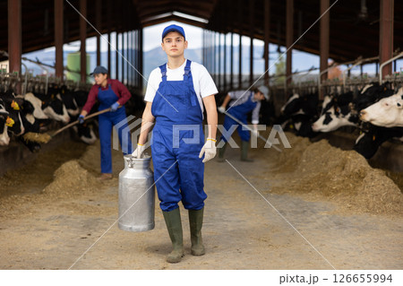 Farmer man holds milk can at cow farm 126655994