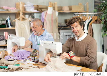 Elderly and adult men tailors sewing on machine 126656016