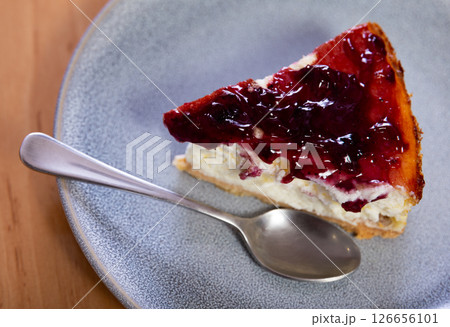 Pieces of cranberry cheesecake tart on wooden table. 126656101
