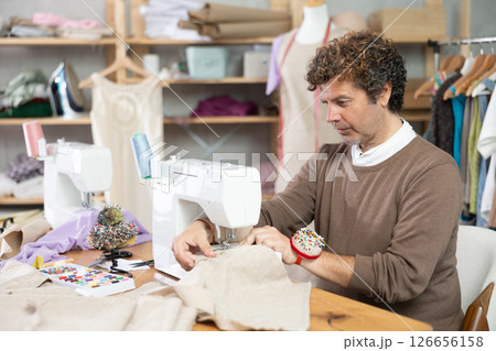 Man working on a sewing machine in a workshop 126656158