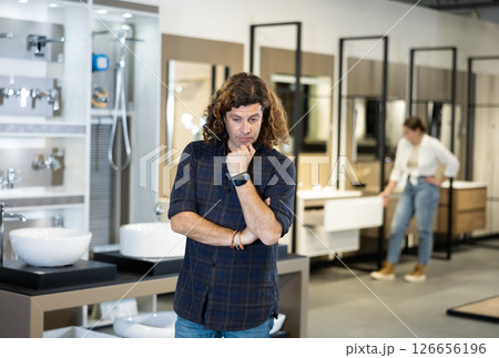 Portrait of male customer making a choice in plumbing and building materials store 126656196