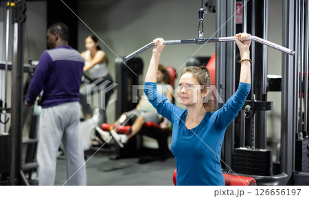 Woman is engaged in a simulator for development of back muscles 126656197