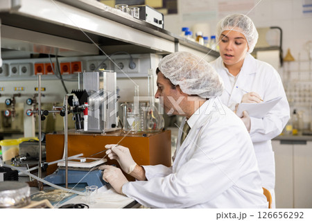 Man and woman scientists chemists conduct experiments in the laboratory Man and woman scientists chemists conduct experiments in the laboratory 126656292