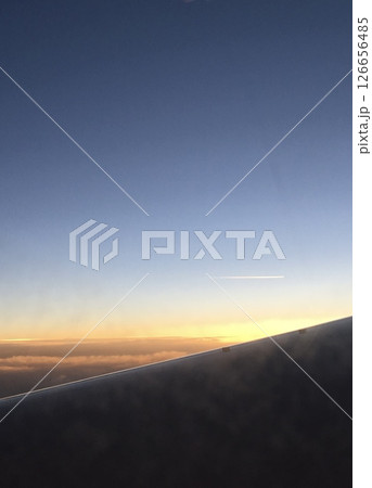 夕暮れフライト｜飛行機の窓からの美しいグラデーションと飛行機雲 126656485