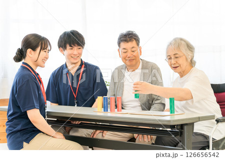 介護施設・リハビリ施設で働く作業療法士の職員とリハビリをするシニア女性 126656542