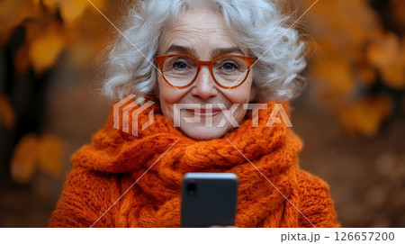 Charming senior woman with stylish glasses enjoying mobile connection 126657200