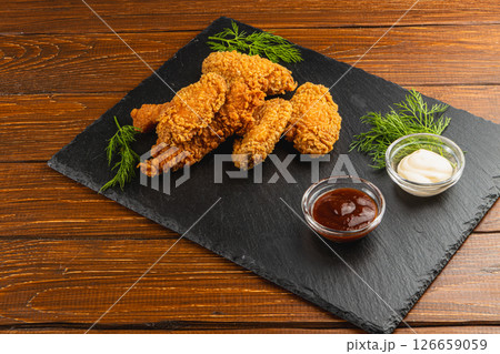 Delicious fried chicken served with dipping sauces on slate board Delicious fried chicken served with dipping sauces on slate board 126659059