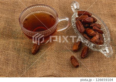 Enjoying tea and dates on a rustic burlap background 126659104