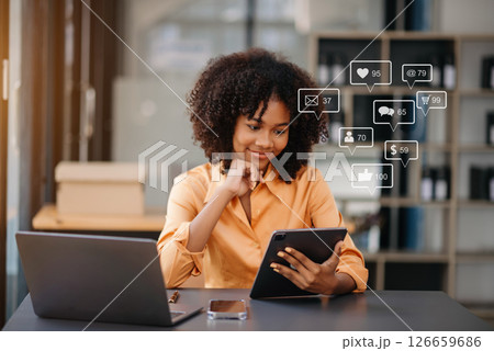 Asian woman typing smartphone, keyboard with laptop computer of Social media and Marketing virtual icons screen concept. Asian woman typing smartphone, keyboard with laptop computer of Social media and Marketing virtual icons screen concept. 126659686