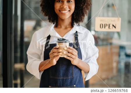 Coffee Business Concept Beautiful lady smiling at camera offers disposable take away hot coffee at coffee shop Coffee Business Concept Beautiful lady smiling at camera offers disposable take away hot coffee at coffee shop 126659768
