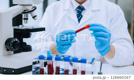 Male scientist researcher conducting an experiment in a laboratory. Male scientist researcher conducting an experiment in a laboratory. 126660167