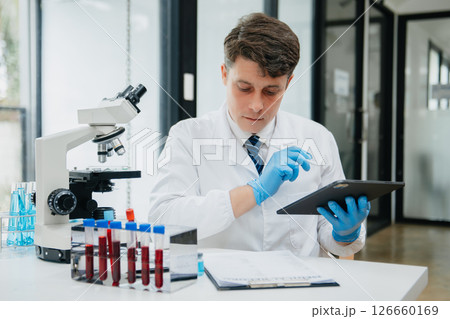 Male scientist researcher conducting an experiment in a laboratory. Male scientist researcher conducting an experiment in a laboratory. 126660169