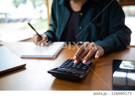 businesswoman or accountant hand typing laptop working to calculate on desk about cost at home office. 126660173