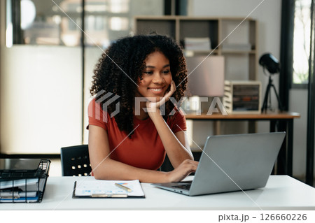 Young woman typing on tablet and laptop while sitting at the working in office 126660226