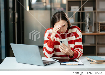 Business woman is stressed, bored, and overthinking from working on a tablet at office. Business woman is stressed, bored, and overthinking from working on a tablet at office. 126660564
