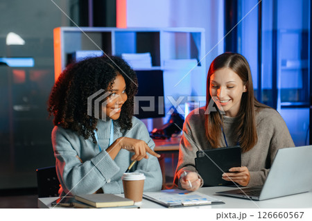 Businesswoman leading team meeting and using tablet and laptop computer with financial. overtime 126660567