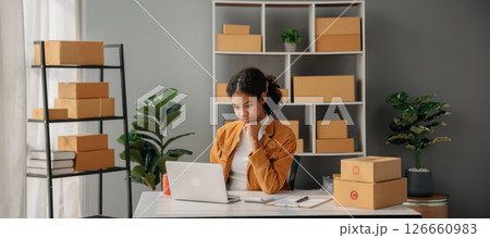 Young African woman prepare parcel box and standing check online orders for deliver to customer on tablet, laptop Shopping Online concept. Young African woman prepare parcel box and standing check online orders for deliver to customer on tablet, laptop Shopping Online concept. 126660983