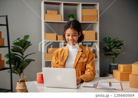 Young African woman prepare parcel box and standing check online orders for deliver to customer on tablet, laptop Shopping Online concept. 126660984