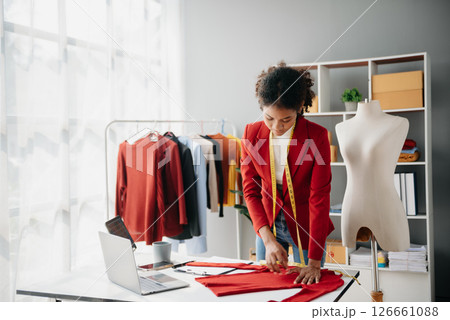 Diverse female fashion designers at work with tailor centimeters on necks and holds tablet and smartphone. independent creative design business. 126661088