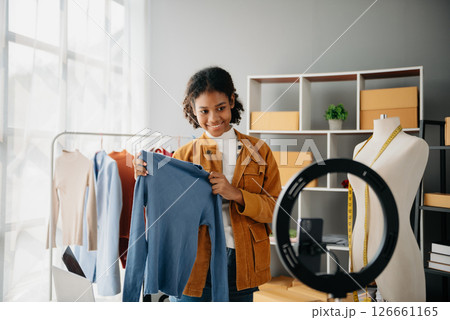 Diverse female fashion designers at work with tailor centimeters on necks and holds tablet and smartphone. independent creative design business. 126661165